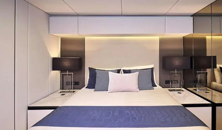 Master cabin with king bed, plush pillows, and built-in nightstands