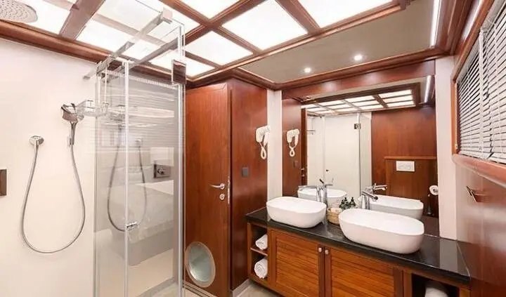 Bathroom cabin on Lady Gita yacht with double sink vanity and glass shower