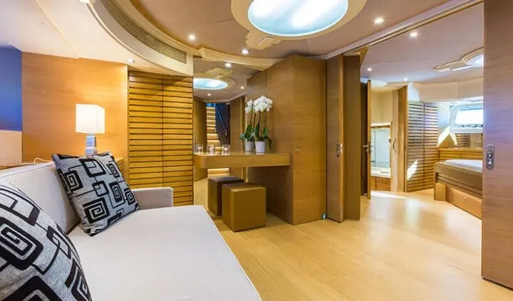 Master cabin with king bed, ensuite, wood paneling and soft lighting on yacht
