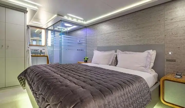 Cozy cabin bedroom on Sea Wolf yacht with bed, pillows, and wardrobe