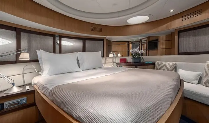 Master cabin with king bed, white bedding, wooden panels, and ensuite area