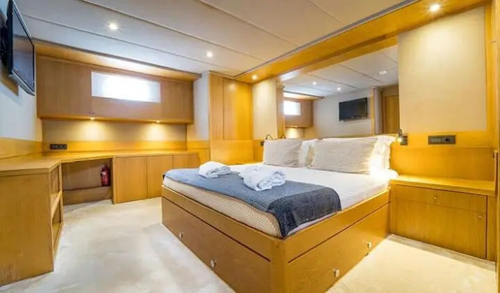 Interior view of Happy Days cabin with double bed, wood cabinetry, and seating