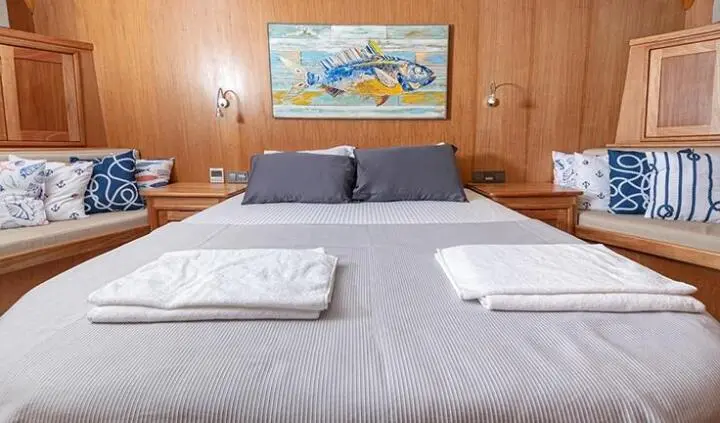 Bodrum Queen master cabin with large bed, wood walls, and framed artwork
