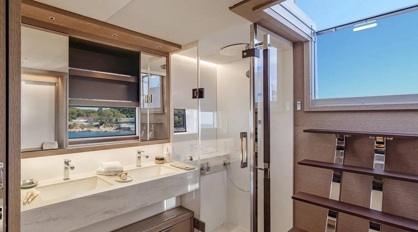 Interior bathroom on Daiquiri yacht with marble sink, mirror, and shower door