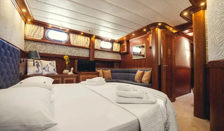 Luxurious yacht cabin with two single beds and wood-paneled walls