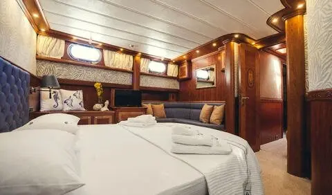 Luxurious yacht cabin with two single beds and wood-paneled walls