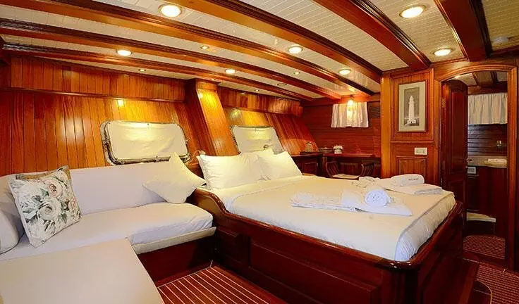 Master cabin with two single beds, wooden paneling, and an ensuite door