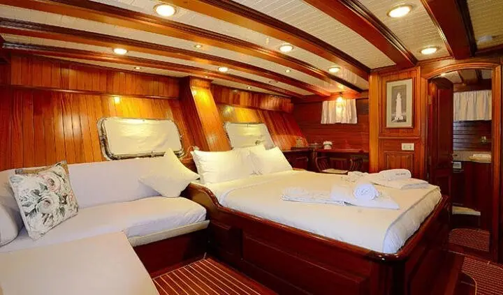 Master cabin with two single beds, wooden paneling, and an ensuite door