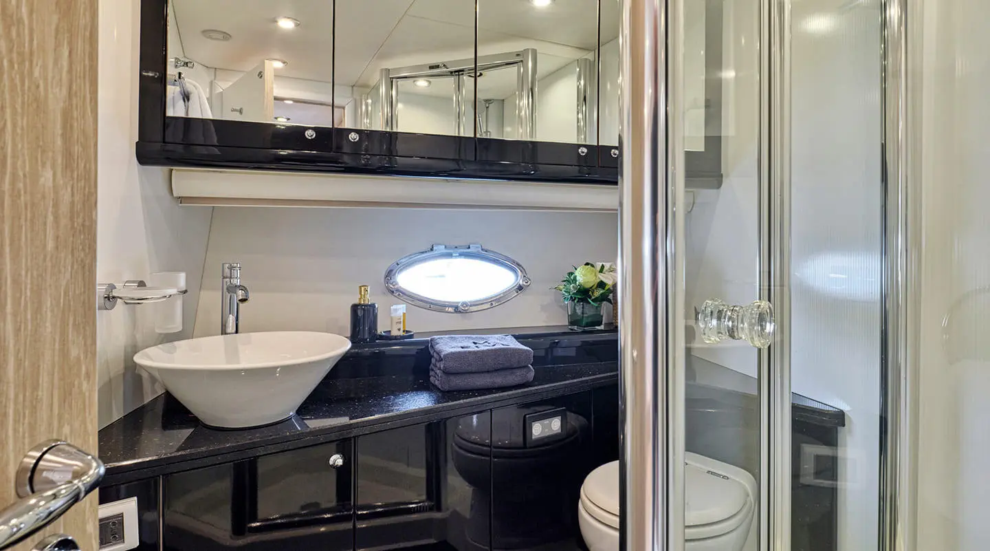 Interior view of a luxury yacht bathroom with mirror, sink, and seating area