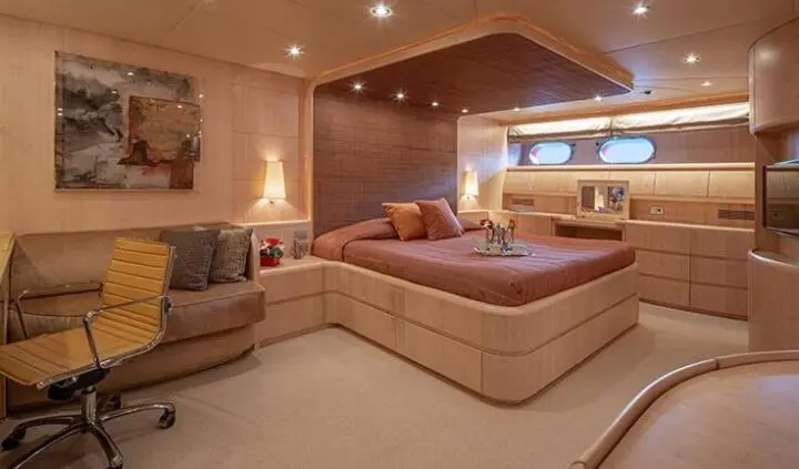 Glaros yacht master cabin with large bed, wood cabinetry, and ensuite area