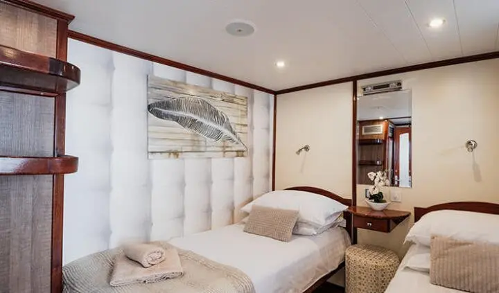 Twin-cabin yacht Mendula interior with wood accents, bed, and built-in storage