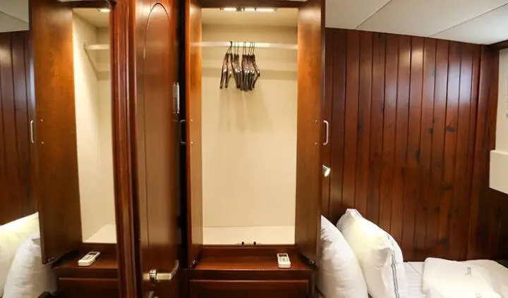 Ulucinar yacht cabin interior with polished wood wardrobes and a hanging rail