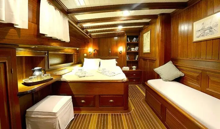 Master cabin with king bed, wood cabinetry, and ensuite visible on Ecce Navigo yacht