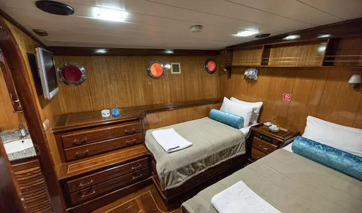 Yacht Kayhan 8 cabin interior showing wood panels and two twin beds
