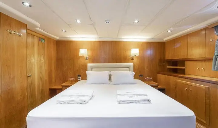 Queen Of Sea cabin with double bed, white linens, warm wood interior