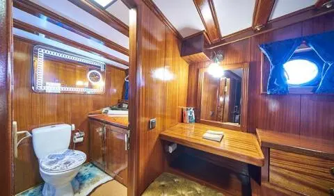 Stella Maris master cabin with king bed and ensuite, wood paneling and mirrors
