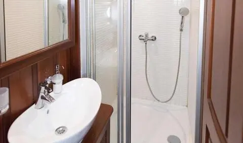 Primadonna cabin: compact ensuite with oval sink and glass shower enclosure