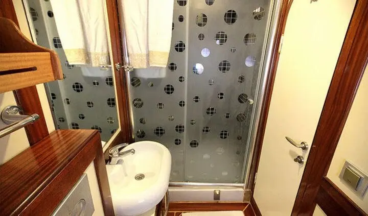 Angelo II cabin bathroom with shower, wall tiles, and toilet visible