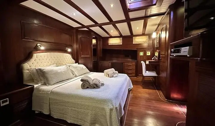 Master cabin with king bed, wooden paneling, ensuite bathroom, warm lighting