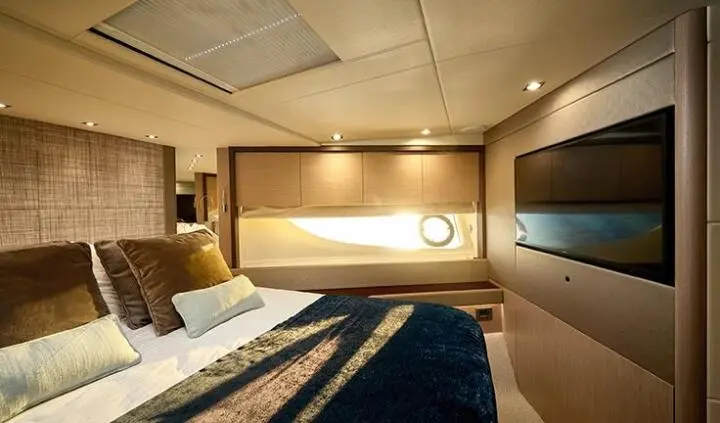 A yacht cabin interior with a double bed, wooden accents, and soft lighting