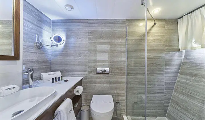 Inside cabin bathroom on Corsario yacht, includes toilet, sink, and glass shower