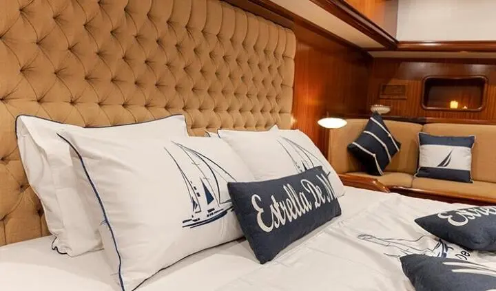 Estrella De Mar master cabin with king bed and tufted headboard, navy pillows