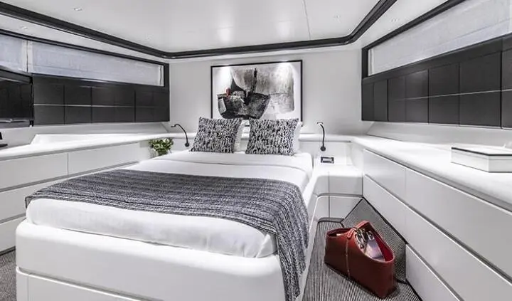 Master cabin with king bed, plush linens, and seating area aboard Project Steel
