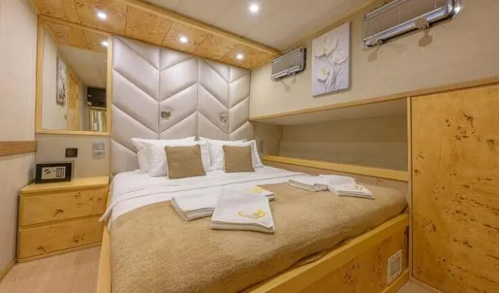 Master cabin with king bed, beige quilted headboard and pendant lamps
