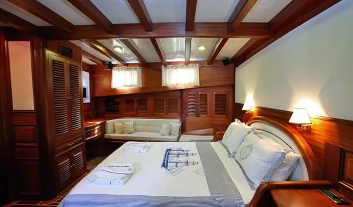 Master cabin with king bed, wooden cabinetry, and ensuite layout