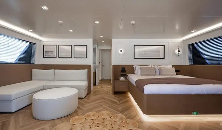 Master cabin with king bed, ensuite, and seating area on yacht Illusion II