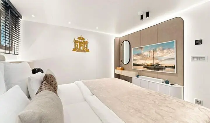 Master cabin with king bed, ensuite, portholes, and beige tones