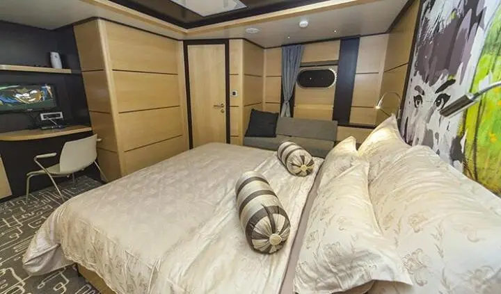 Navilux master cabin with king bed, plush bedding, beige upholstery, built-in wardrobes
