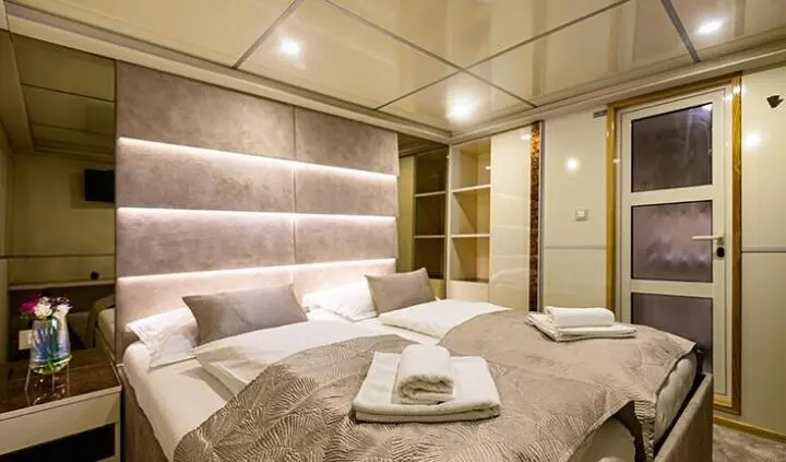 Melody yacht master cabin with a king bed, ensuite bathroom, neutral décor