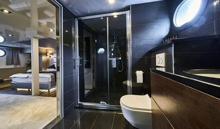 Master cabin with king bed, ensuite and navy decor on Rara Avis yacht
