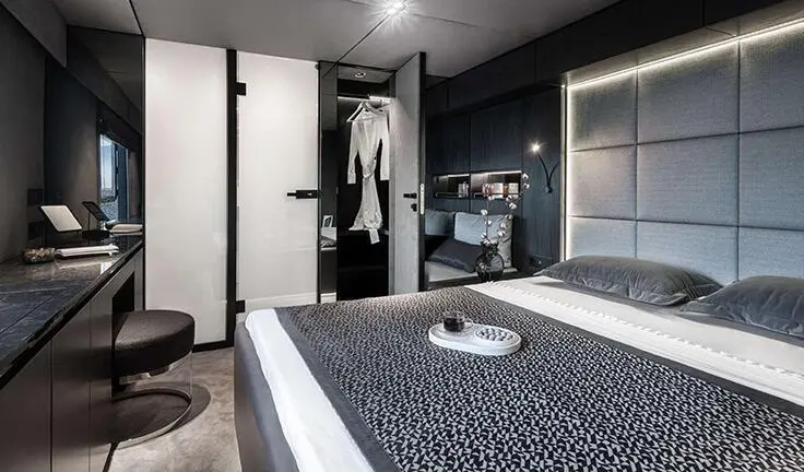 Master cabin with queen bed, dark bedding, and ensuite door visible