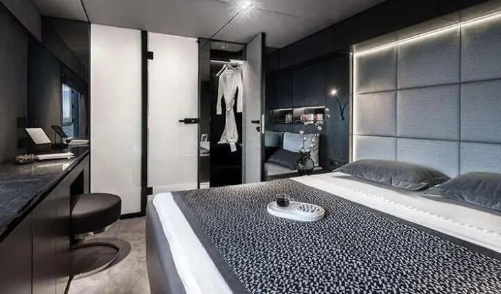 Master cabin with queen bed, dark bedding, and ensuite door visible