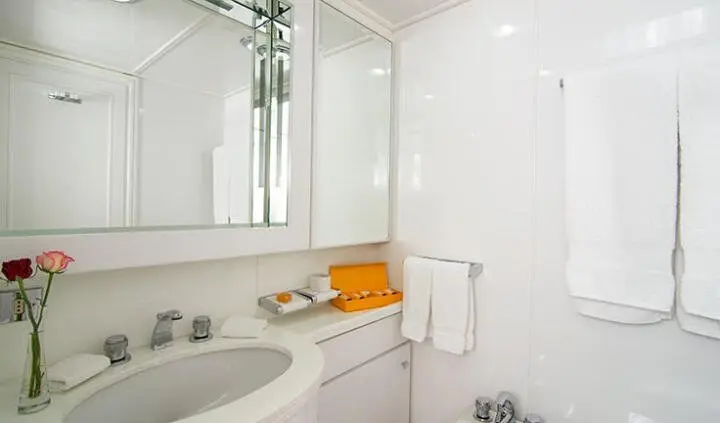 Yacht O'Natalina master cabin with king bed, ensuite visible, white glossy surfaces