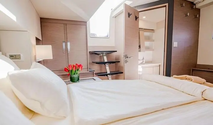 Master cabin with king bed, white linens, ensuite entry on yacht Astoria