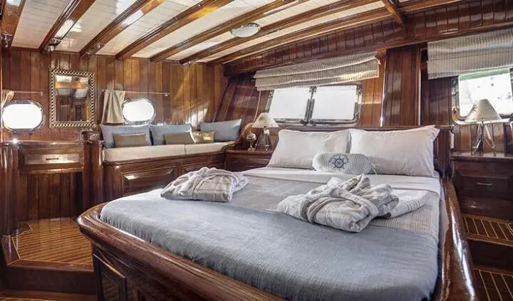 Master cabin with king bed, wooden beams, ample pillows, and ensuite vibe