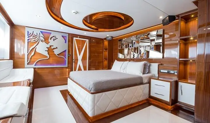 Master cabin with king bed and ensuite, warm wood panels, built-in seating