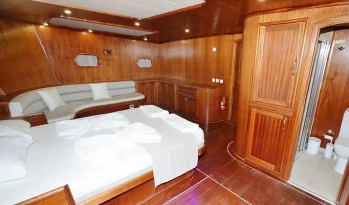 Master cabin with two beds, wood-paneled walls, and ensuite progress door