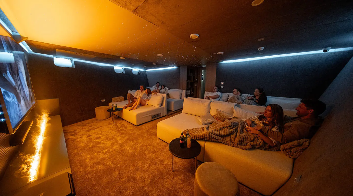 Interior of Cristal yacht cinema room with plush seating and warm lighting
