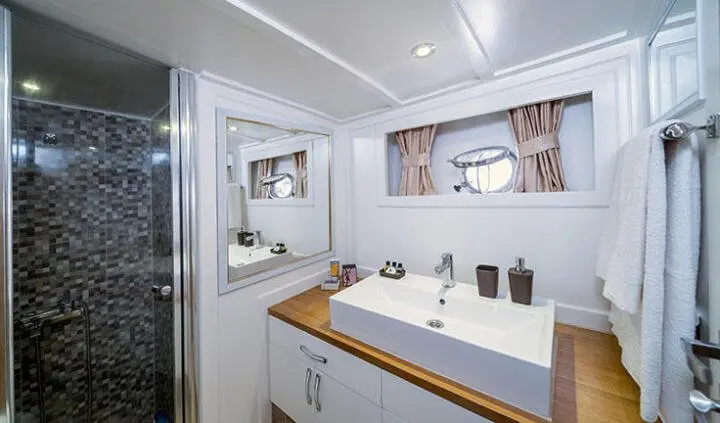 Maske yacht master cabin with king bed, ensuite, window view, wood accents