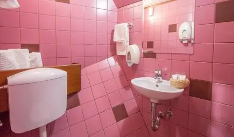 Altair yacht cabin interior with pink tiled walls, compact sink, mirror, and towels