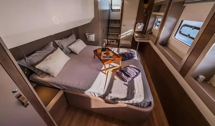 Ocean Lounge cabin aboard a yacht with bed, seating, and wooden interior