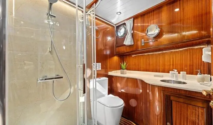 Small cabin with wooden shelves, mirror, and bed in yacht master suite