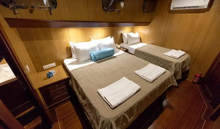 Twin-cabin ensuite beds on Kayhan 3 yacht, neatly made with pillows