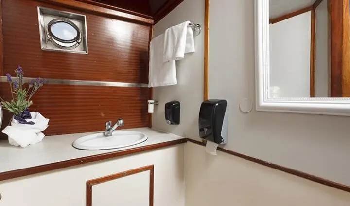 Master cabin with king bed, ensuite door, and wooden accents on port side