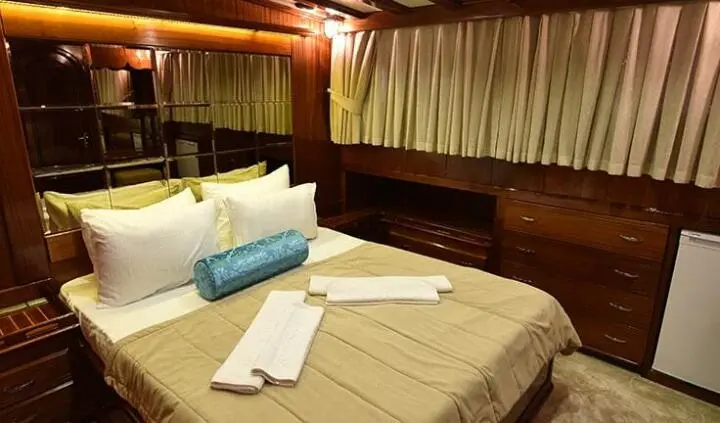 Double cabin with bed, pillows, and ensuite space aboard Kayhan Kaptan yacht