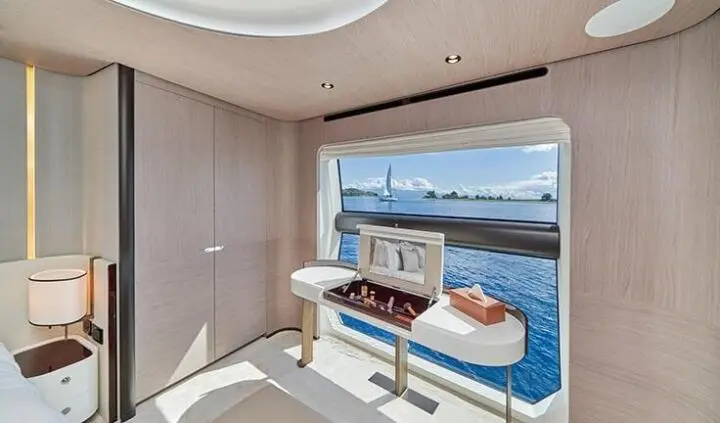 Interior cabin with bed and built-in cabinetry, ocean view through window